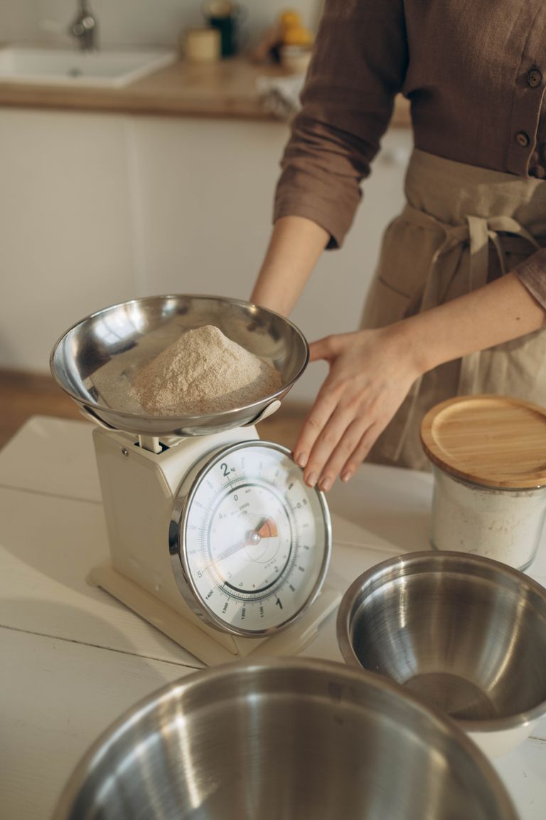Woman weighing flour with a kitchen scale